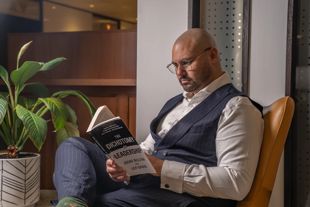 Man reading a book in a cozy setting.