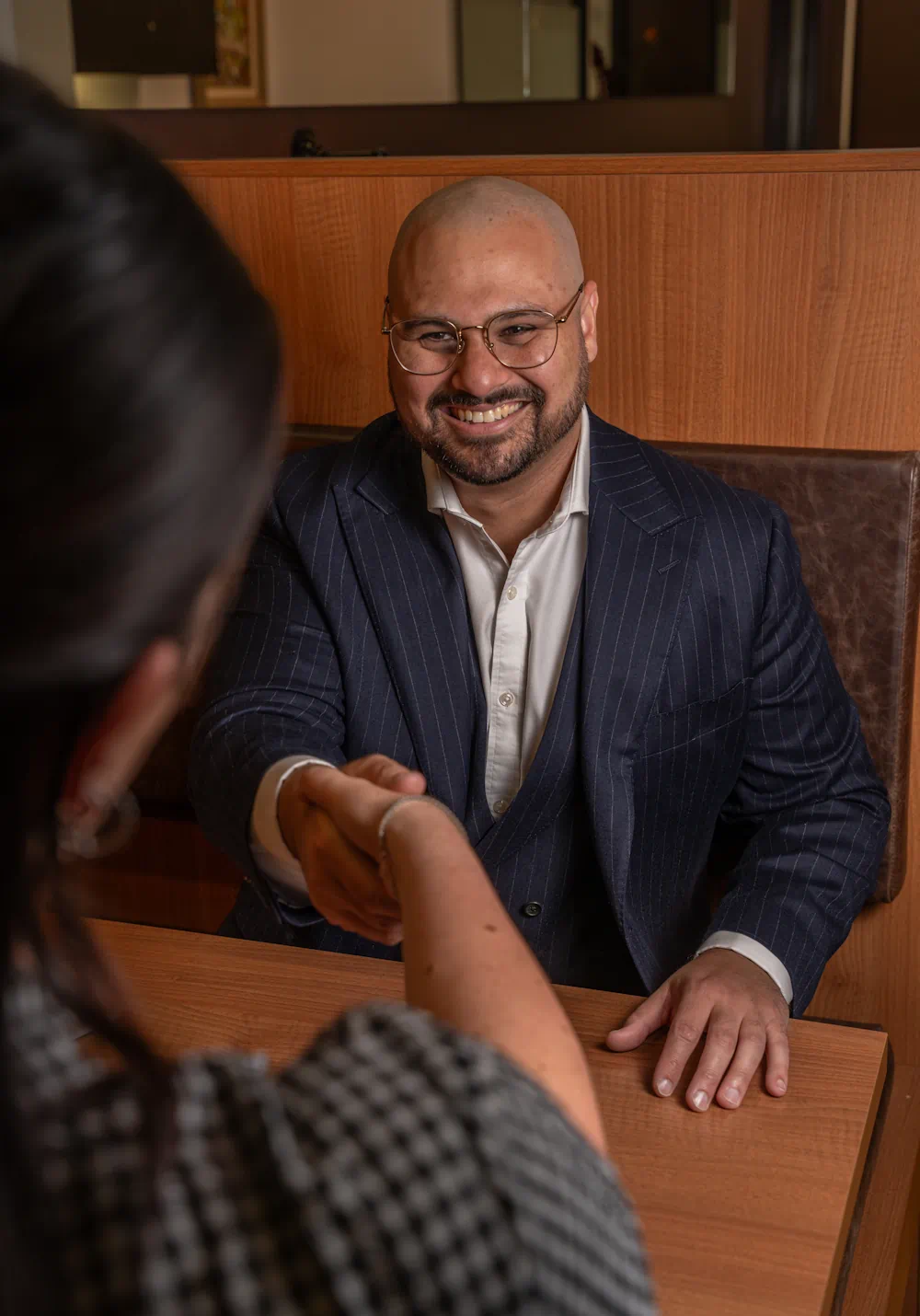 Two people shaking hands in a meeting.
